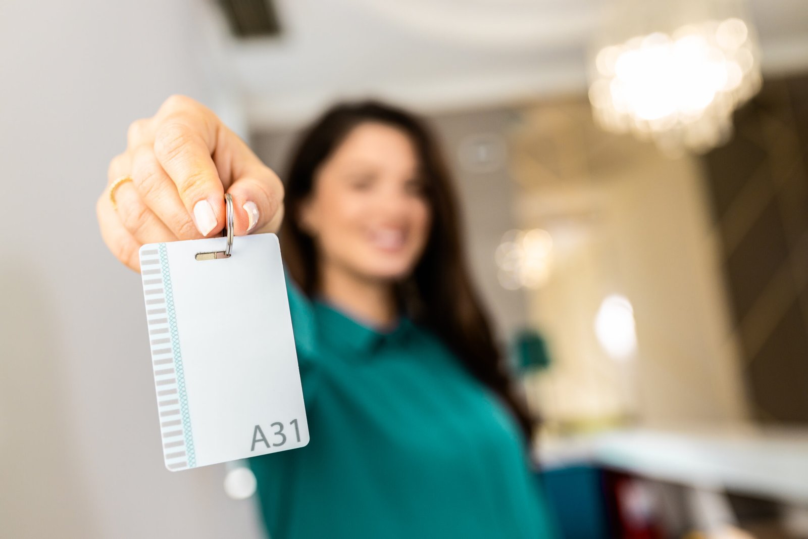 Portrait of female receptionist showing key card towards the cam