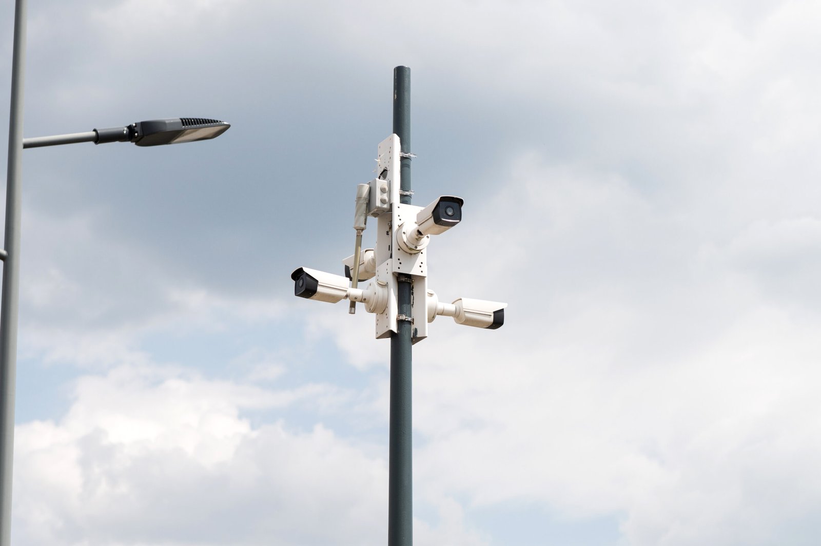 Urban Surveillance Cameras Against Cloudy Sky
